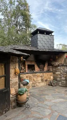 a stone building with a chimney on top of it at Casa Rural Dorinda in Campelo