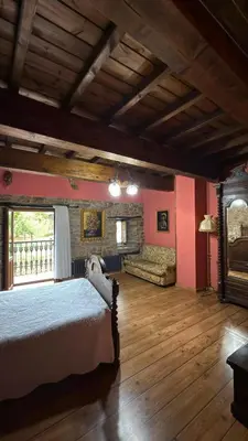 a bedroom with a bed and a couch in a room at Casa Rural Dorinda in Campelo