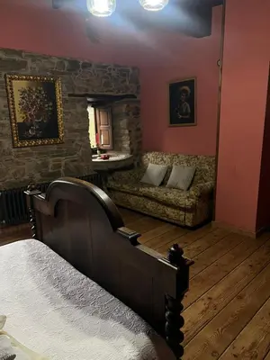 a bedroom with a bed and a couch in a room at Casa Rural Dorinda in Campelo