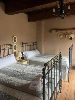 a bedroom with two beds and a ceiling at Casa Rural Dorinda in Campelo