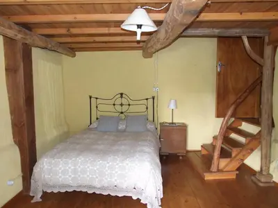 a bedroom with a bed and a wooden floor at Casa Aurora in San Esteban del Toral