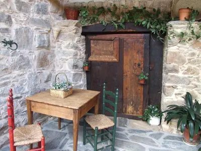 a wooden table with two chairs and a door at Casa Aurora in San Esteban del Toral