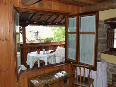 a room with a table and a window with a table and chairs at Casa Aurora in San Esteban del Toral
