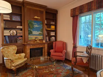 a living room with two chairs and a fireplace at Oasis Ponte San Lázaro in Santiago de Compostela