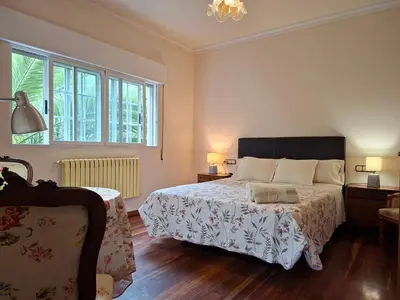 a bedroom with a bed and a couch and windows at Oasis Ponte San Lázaro in Santiago de Compostela
