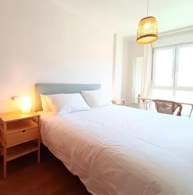 a bedroom with a large white bed and a table at Alojamiento con vistas ría de Viveiro-Misericordia in Viveiro