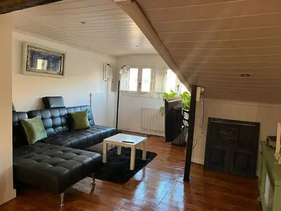 a living room with a leather couch and a table at Acogedor apartamento del Casco Antiguo de Ourense in Ourense