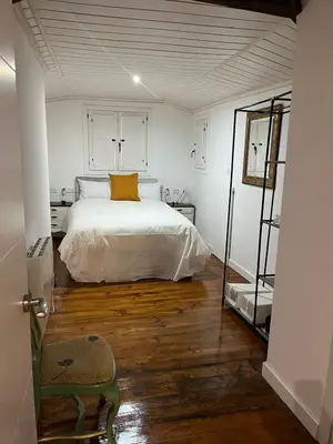 a bedroom with a bed with a yellow pillow on it at Acogedor apartamento del Casco Antiguo de Ourense in Ourense