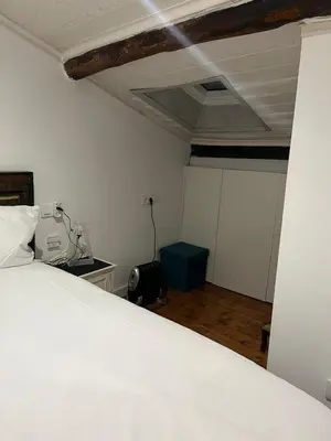 a bedroom with a white bed and a ceiling at Acogedor apartamento del Casco Antiguo de Ourense in Ourense