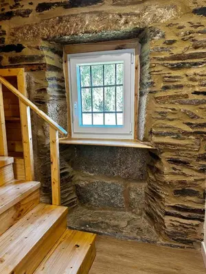 a room with a window in a stone wall at A Casiña da Ponte in Lugo