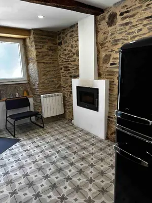 a living room with a tile floor and a fireplace at A Casiña da Ponte in Lugo