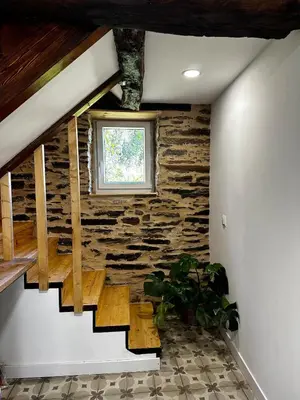 a staircase in a house with a stone wall at A Casiña da Ponte in Lugo
