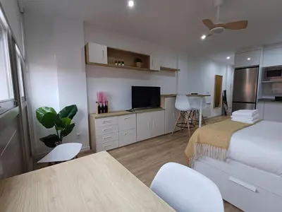a bedroom with a bed and a table and a tv at Precioso loft para disfrutar de Ourense in Ourense