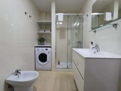 a bathroom with a sink and a washing machine at Precioso loft para disfrutar de Ourense in Ourense