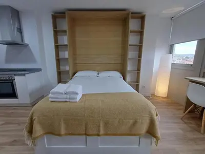 a bedroom with a large bed with towels on it at Precioso loft para disfrutar de Ourense in Ourense