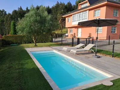a swimming pool with two chairs and an umbrella at Casa en el Valle in Santa Eulalia