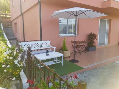 a patio with a white bench and an umbrella at Casa en el Valle in Santa Eulalia
