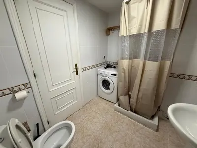 a bathroom with a toilet and a washing machine at ps 43 Vut in Lugo