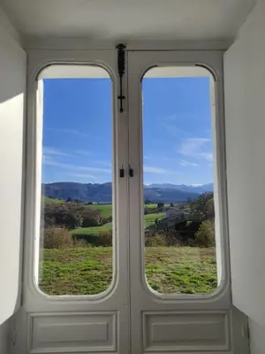 two windows in a door with a view of a field at Habitaciones Rurales Los Semellones in La Llama