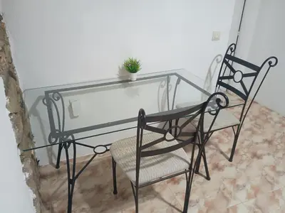 a glass table and a chair with a plant on it at Habitaciones Rurales Los Semellones in La Llama