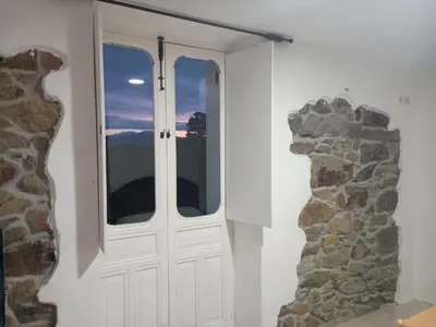a door in a room with a stone wall at Habitaciones Rurales Los Semellones in La Llama