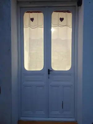 a blue door with two windows with hearts on them at Habitaciones Rurales Los Semellones in La Llama