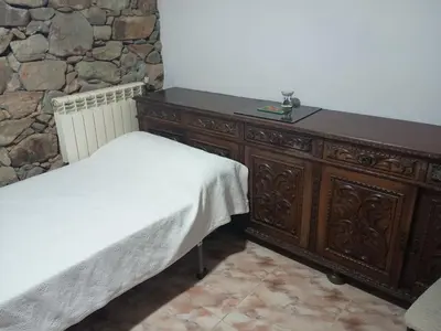 a bedroom with a wooden bed and a wooden dresser at Habitaciones Rurales Los Semellones in La Llama