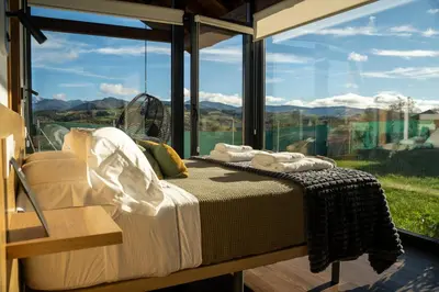 a bedroom with a bed in front of a large window at Cabanas do Chao