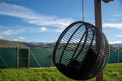 a black basket swing hanging from a chain at Cabanas do Chao