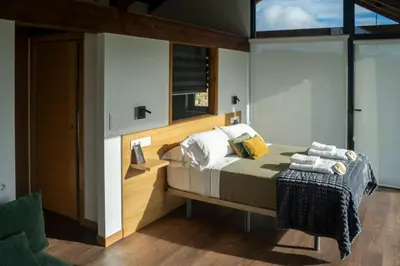 a bedroom with a bed with a wooden headboard at Cabanas do Chao