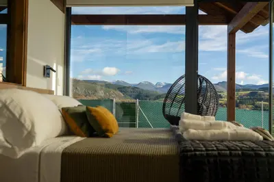 a bedroom with a bed and a large window at Cabanas do Chao