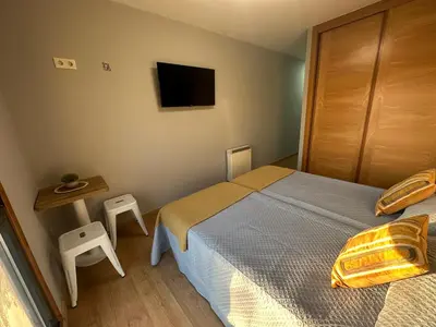 a bedroom with a bed and a table and a television at Pensión Villa Mayer - Grupo Arcanos in Caldas de Reis
