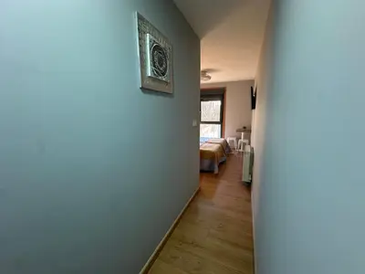 a hallway leading to a bedroom with a bed at Pensión Villa Mayer - Grupo Arcanos in Caldas de Reis
