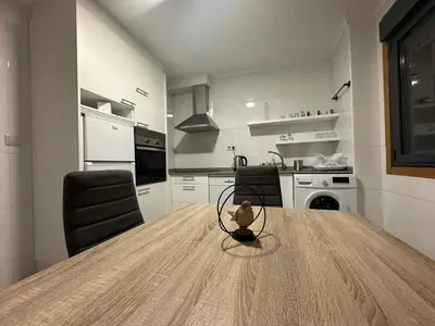 a kitchen with a large wooden table in a room at Pensión Villa Mayer - Grupo Arcanos in Caldas de Reis