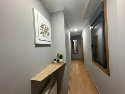 a hallway with white walls and a wooden bench on a wall at Pensión Villa Mayer - Grupo Arcanos in Caldas de Reis