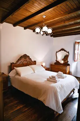 a bedroom with a large white bed with a chandelier at Casa do Botas in Sober