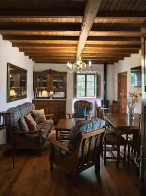 a living room with a wooden ceiling and a table and chairs at Casa do Botas in Sober
