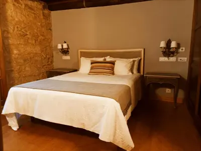 a bedroom with a large bed with two night stands at Vila As Pedras in Roxos