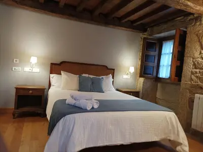 a bedroom with a large bed with red pillows at Vila As Pedras in Roxos