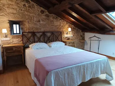 a bedroom with a large bed with towels on it at Vila As Pedras in Roxos
