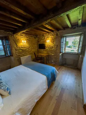 a bedroom with a large bed with red pillows at Vila As Pedras in Roxos