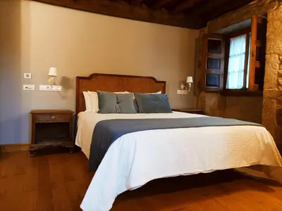 a bedroom with a large bed and a window at Vila As Pedras in Roxos