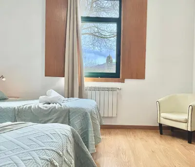 a bedroom with two beds and a window at Complexo Xacobeo in Tríacastela