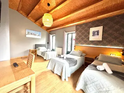 a room with two beds and a table at Complexo Xacobeo in Tríacastela