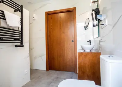 a bathroom with a wooden door and a toilet at Complexo Xacobeo in Tríacastela