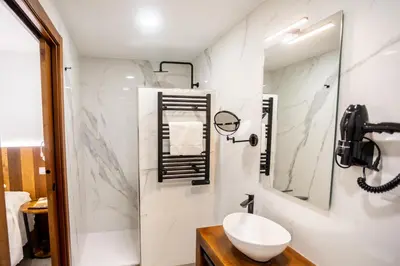a white bathroom with a sink and a mirror at Complexo Xacobeo in Tríacastela