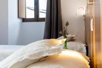 a bedroom with a bed with pillows and a window at Complexo Xacobeo in Tríacastela