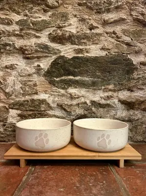 two bowls sitting on a wooden shelf in front of a stone wall at A Maquía de Medín in O Pino