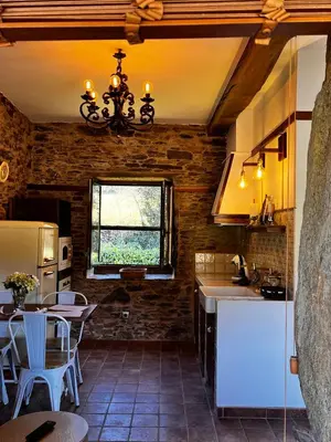 a kitchen with a sink and a table at A Maquía de Medín in O Pino