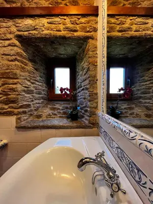 a bathroom with a sink and two windows at A Maquía de Medín in O Pino
